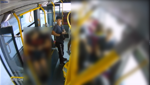 Na zdjęciu z kamery umieszczonej w autobusie widoczny jest młody, niski mężczyzna, który stoi w korytarzu nieopodal pokrzywdzonego.