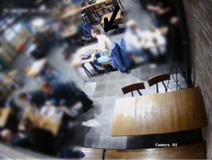 Na zdjęciu widoczny jest mężczyzna siedzący przy stoliku w restauracji