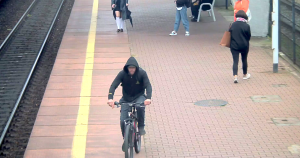 Na zdjęciu widoczny jest mężczyzna jadący rowerem po peronie dworca