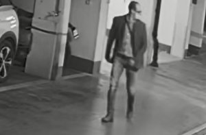 Na zdjęciu widoczny jest mężczyzna idący po parkingu podziemnym