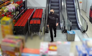 Na zdjęciu widoczny jest mężczyzna chodzący po sklepie spożywczym