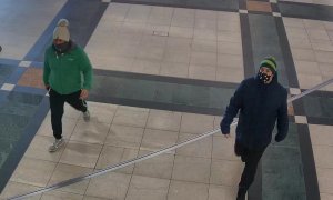 Na zdjęciu widoczni są dwaj mężczyźni idący chodnikiem