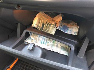 Na zdjęciu widoczne są pieniądze ukryte w schowku samochodowym
