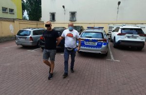 Na zdjęciu widoczny jest zatrzymany mężczyzna prowadzony przez policjantów