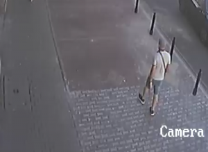 Na zdjęciu widoczny jest mężczyzna idący chodnikiem