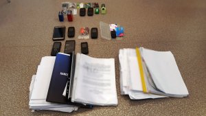 Na zdjęciu widoczne są przedmioty, telefony i dokumenty leżące na stole