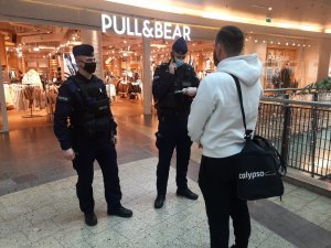 Policjanci kontrolują  i egzekwują obowiązek noszenia maseczek w centrach handlowych