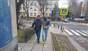 Na zdjęciu widoczny jest zatrzymany mężczyzna prowadzony przez policjanta