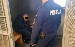Na zdjęciu widoczny jest zatrzymany mężczyzna siedzący w celi