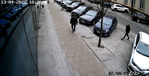 Na zdjęciu widoczni są mężczyźni idący chodnikiem