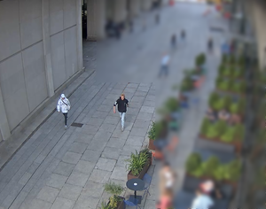 Na zdjęciu widoczni są mężczyźni idący chodnikiem