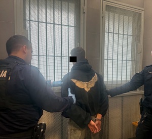 Policjanci trzymający zatrzymanego
