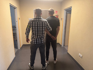 Policjant trzymający zatrzymanego
