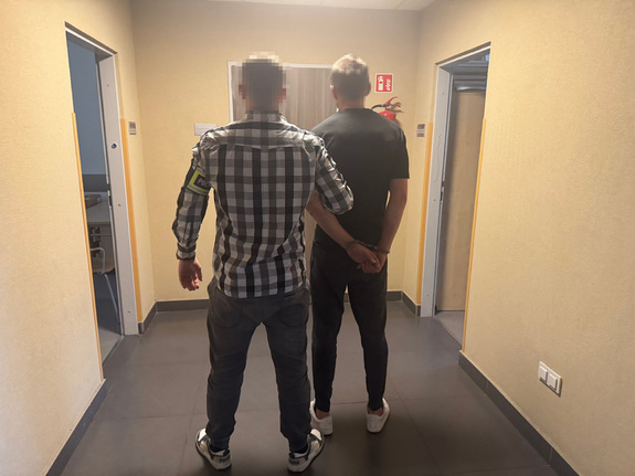 Policjant trzymający zatrzymanego