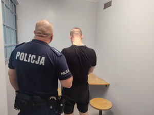 Policjant trzymający zatrzymanego